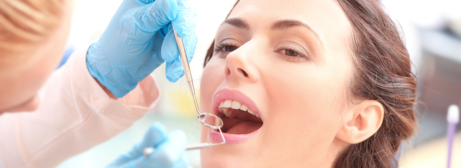 Woman receiving dental treatment with a needle in her mouth.