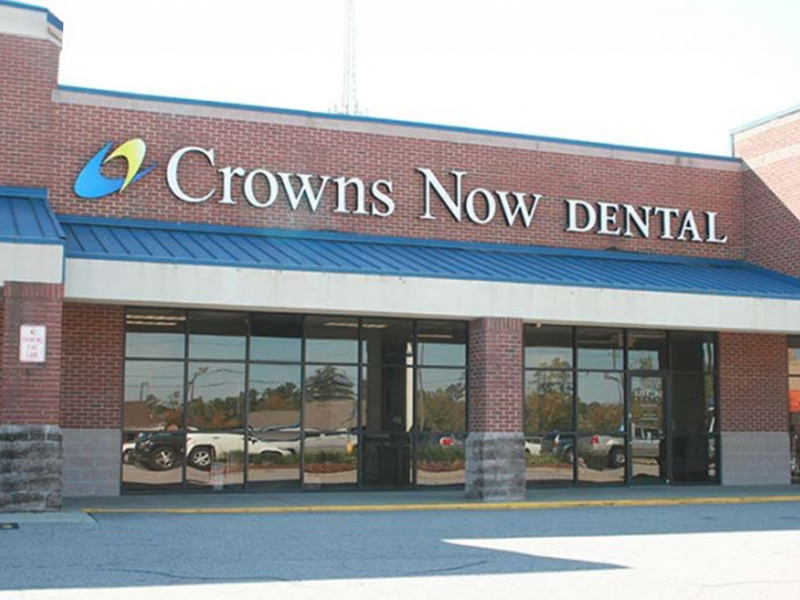 The image shows a storefront with the name Crowns Now Dental prominently displayed, indicating a dental practice.
