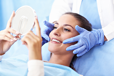 A person sitting on a dental chair, receiving oral care from a dentist.